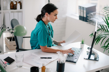 young beautiful doctor in medical office. female doctor working on analysis.