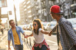 © BalanceFormCreative - Group of friends hangout at the city street.They hold hands and laughing.
