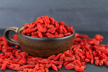 Wall Mural - Goji berry cup many dried goji berries on grey slate. Selective focus