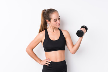 Young caucasian sporty woman holding a dumbbell