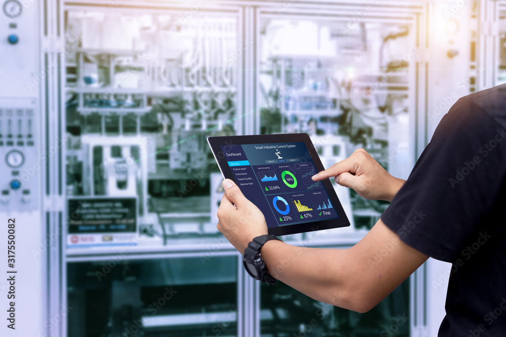 Smart industry control concept.Hands holding tablet on blurred automation machine as background - obrazy, fototapety, plakaty 