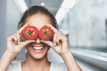 Sticker - Beautiful laughing woman holding two ripe tomatoes