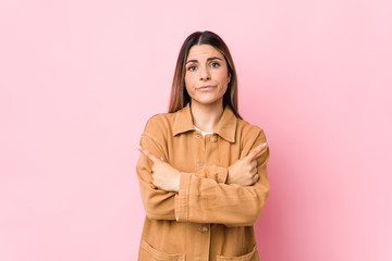 Young caucasian woman isolated points sideways, is trying to choose between two options.