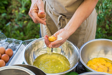 Woman In Apron Separating Egg Yolks From Whites