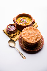 Wall Mural - Dal pakwan is an authentic Sindhi breakfast. It is a combination of deepfried, crisp and unpuffed Maida puris served with Daal made using chana or split chickpea. selective focus