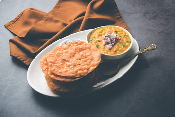 Wall Mural - Dal pakwan is an authentic Sindhi breakfast. It is a combination of deepfried, crisp and unpuffed Maida puris served with Daal made using chana or split chickpea. selective focus