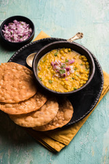 Wall Mural - Dal pakwan is an authentic Sindhi breakfast. It is a combination of deepfried, crisp and unpuffed Maida puris served with Daal made using chana or split chickpea. selective focus