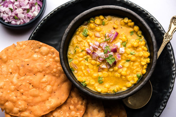 Dal pakwan is an authentic Sindhi breakfast. It is a combination of deepfried, crisp and unpuffed Maida puris served with Daal made using chana or split chickpea. selective focus