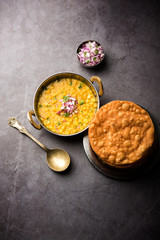 Wall Mural - Dal pakwan is an authentic Sindhi breakfast. It is a combination of deepfried, crisp and unpuffed Maida puris served with Daal made using chana or split chickpea. selective focus