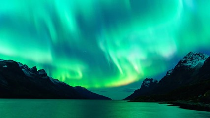 cinemagraph of aura borealis lights at night reflected in the sea