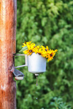 Fototapeta Perspektywa 3d - Old rural metal washstand with the wreath of yellow Rudbeckia flowers hanging on wooden pole on country yard