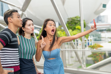 Sticker - Three asian friends taking selfies outdoor. Friendship and holiday concept