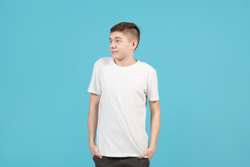 Wall Mural - A teenager in a white T-shirt looks uncertainly to the right