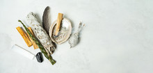 Smudge Kit For Spiritual Practices With Natural Elements: Palo Santo Sticks, Dried White Sage, Guinea Fowl Feather, Crystals, Sea Pearl Shell Abalone On A Light Background. Balancing The Soul.
