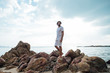© Anna - A man on the tropical coast in stones by the sea.