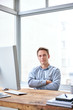 © marvent - Confident young businessman at his desk with arms folded