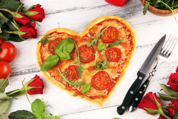 pizza Heart shaped margherita with tomatoes and mozzarella vegetarian. Food concept of romantic love pizza for Valentines Day.