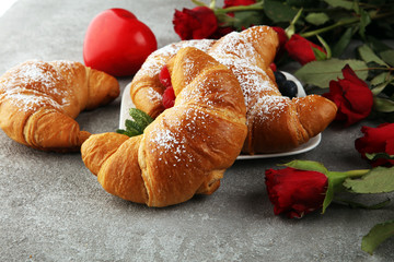 Delicious breakfast with fresh croissants and ripe berries and mint for valentines day