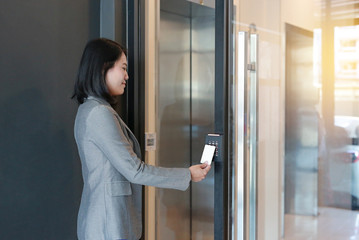 Door access control - young officer woman holding a key card to lock and unlock door for access entry.