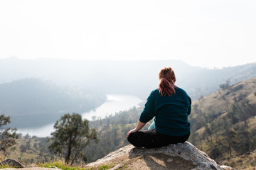 woman sitting on top of mountain