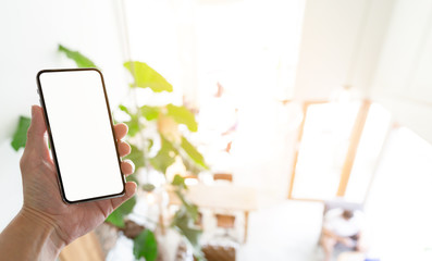 Mockup image blank white screen cell phone.man hand holding texting using mobile on desk at coffee shop.background empty space for advertise text.people contact marketing business,technology 