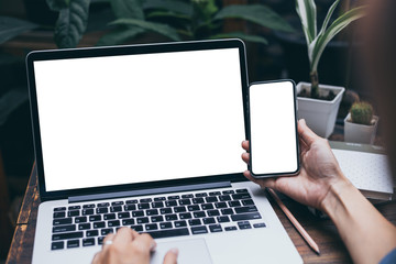mockup image blank screen computer,cell phone with white background for advertising text,hand man using laptop texting mobile contact business search information on desk in cafe.marketing,design