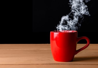 Sticker - A red hot cup of coffee on a wooden desk