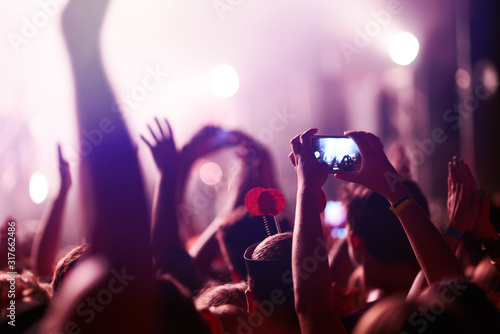 Fotomural Hand with a phone records live music festival