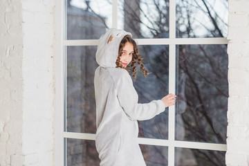 Teenage girl in in fashionable kigurumi pajamas at home