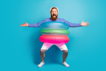 Full body photo of crazy cheerful man enjoy summer vacation want hug his buddy open hands have tree lifesaver wear white shorts sunhat panama isolated over blue color background