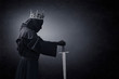 Ghost of a queen or king with medieval sword in the dark