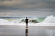 A surfer entering the sea at the Carcavelos Beach in Oeiras, Portugal