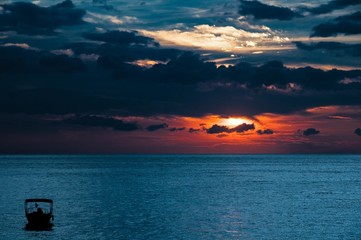 Wall Mural - beautiful shot of a sunrise in the ocean with a cloudy sky