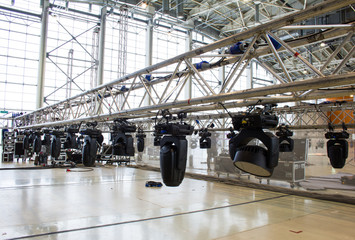 Setup of truss with moving head spotlight devices. Installation of professional stage, sound and light equipment for a concert.