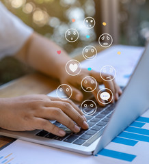 Businessman using a social media marketing concept on laptop computer with notification icons of like, chat, message and comment above laptop keyboard.