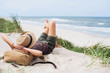 Leinwandbild Motiv Young woman resting by the sea. Girl lying down on the beach. Enjoying life, summer lifestyle, relaxation, mindfulness and travel concept