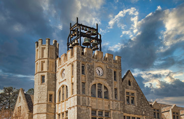 Wall Mural - An old stone bell tower with a clock embedded in the face