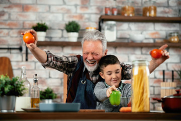 Wall Mural - Grandpa and grandson in kitchen. Grandfather and his grandchild having fun while cooking.