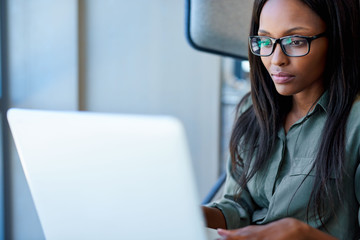 Young executive focused on her online work in an office