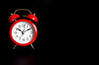 © Ksenia - red round analog alarm clock isolated on black background. time 10:10. space for text