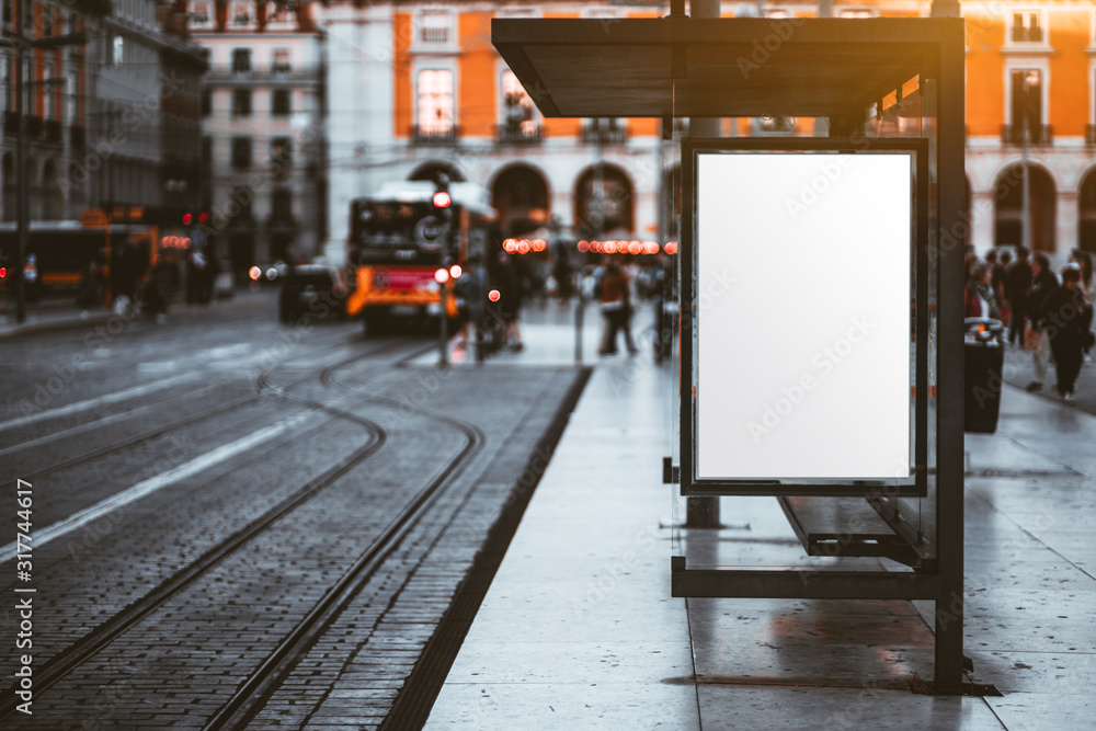 A blank advertising billboard placeholder template on the city street; an empty mock-up of an outdoor poster on a paved tram stop; a white vertical mockup of an urban banner on the bus stop - obrazy, fototapety, plakaty 