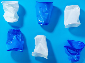 disposable plastic cups on a blue background. the concept of abandoning plastic. the use of plastic