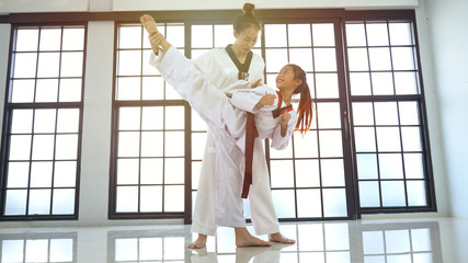 Teacher teaching taekwondo girl