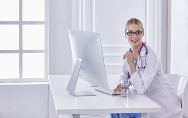 Wall Mural - Portrait of a happy smiling young doctor in headset in office