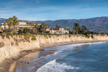 Goleta, CA, USA - January 2, 2020: UCSB, University California Santa Barbara. East Side Beige Cliffs In Front Of Several Buildings. Blue Ocean In Front. Green Foliage Around. Hills On Horizon And Blue