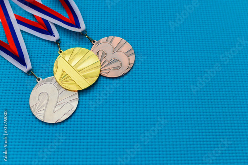 Gold silver and bronze medal on blue background. Medal schedule concept photo, empty edit space. Original wallpaper for summer olympic game in Tokyo 2020
