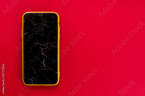 Fotomural Smartphone with broken screen on red background