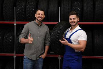 Sticker - Mechanic helping client to choose car tire in auto store