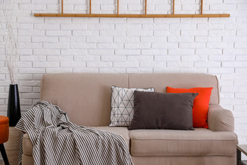 Wall Mural - Soft pillows on sofa near white brick wall