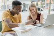 © Cavan Images - Couple of boy and girl laughing on the terrace of a bar